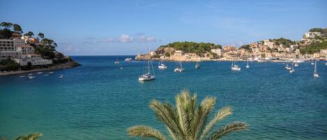 A coastal town with clear waters, boats, and buildings along the shore.