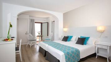 Una habitación de hotel con cama, escritorio, silla y zona de comedor.