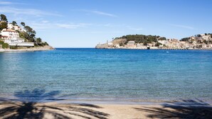 Une vue côtière avec des bâtiments sur une colline et une plage au premier plan.