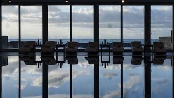 Relax on the balcony overlooking the water with a serene view.