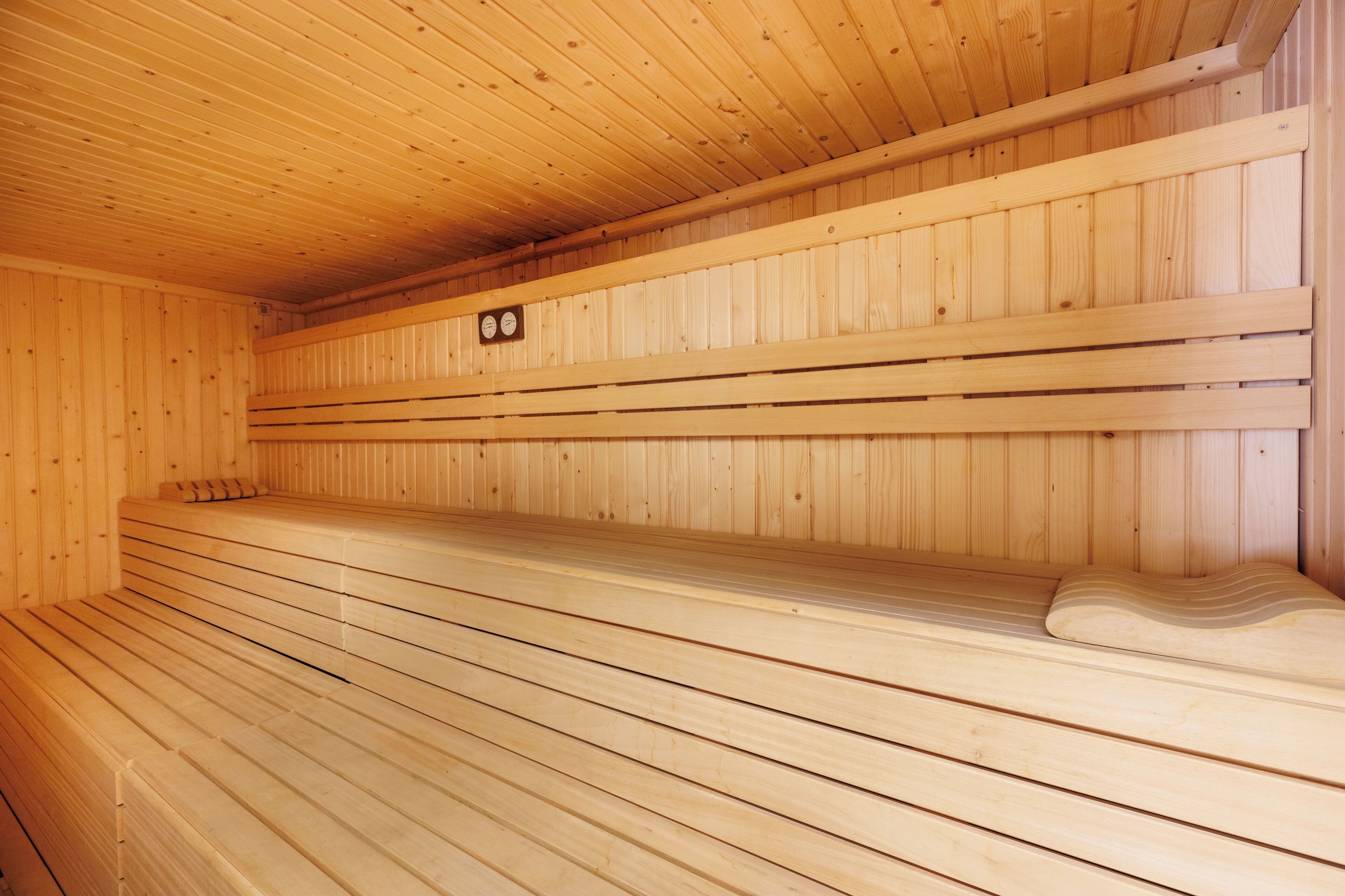 Un sauna avec des bancs en bois et un plafond incliné.