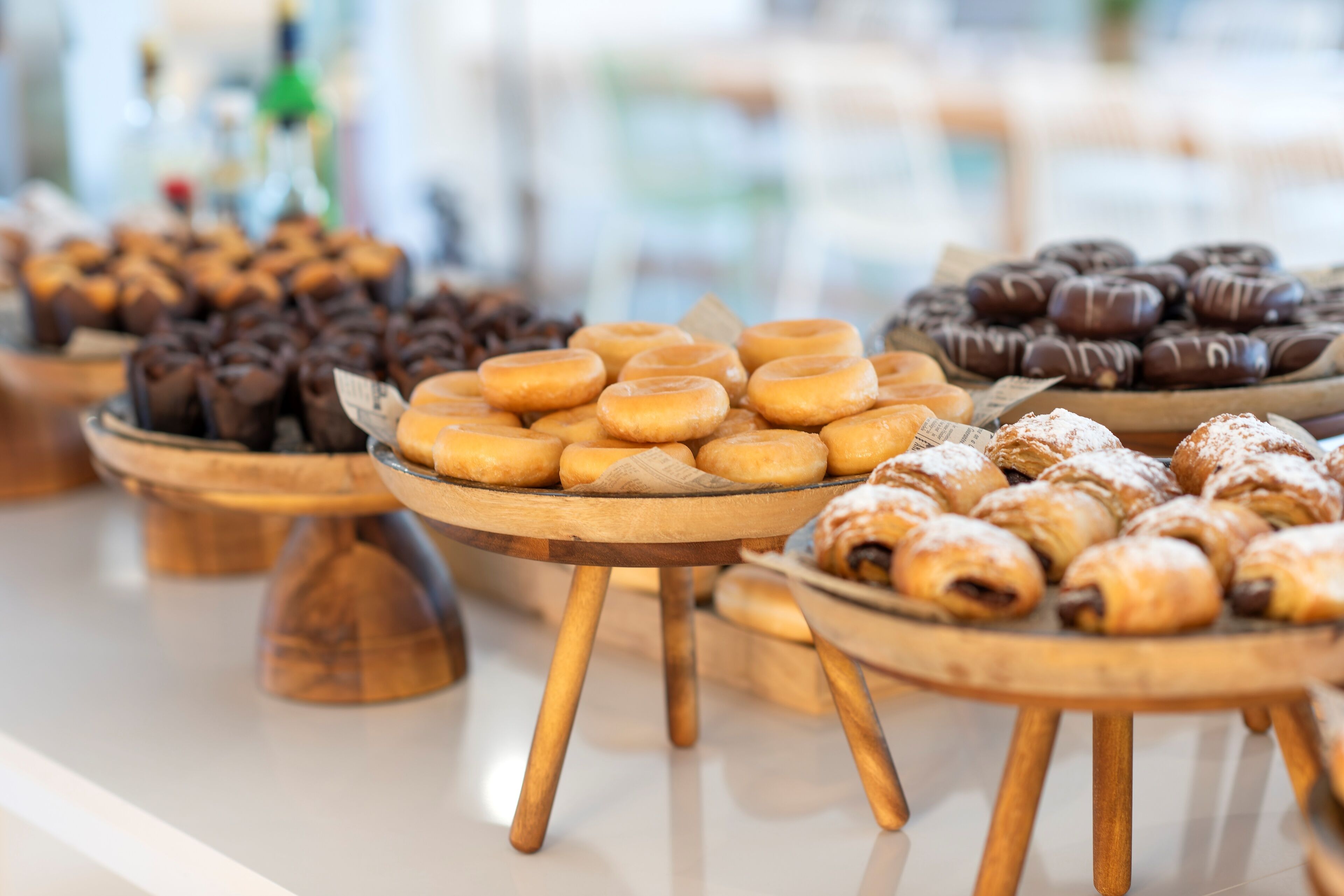 A variety of pastries displayed on wooden stands.