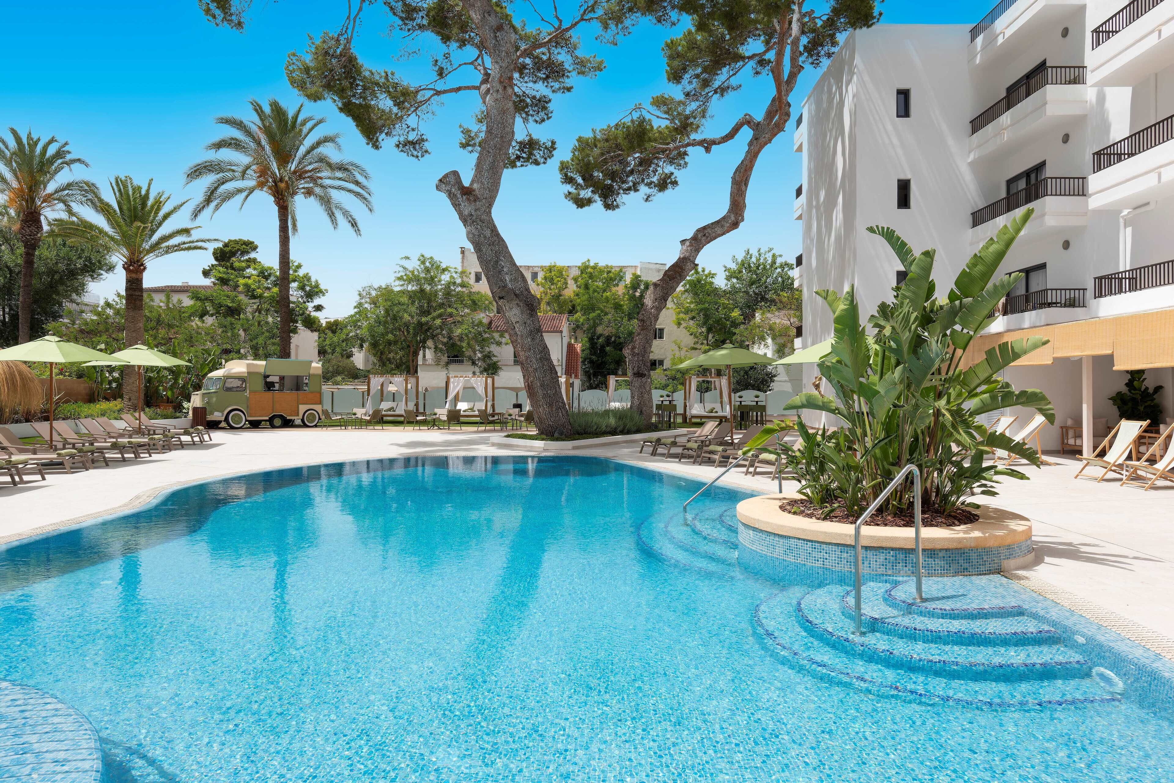 Alberca al aire libre, sombrillas en la alberca y camastros 