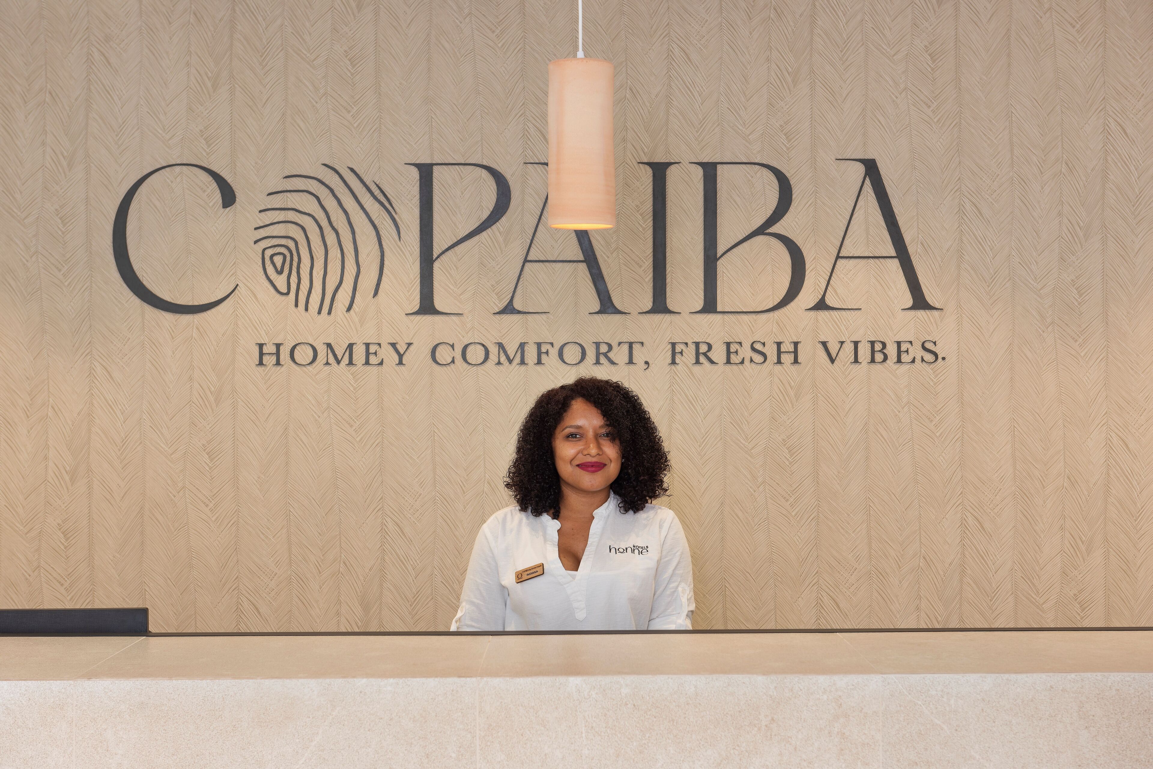 Ein Empfangstresen mit einem PAIBA-Schild und einem Namensschild.