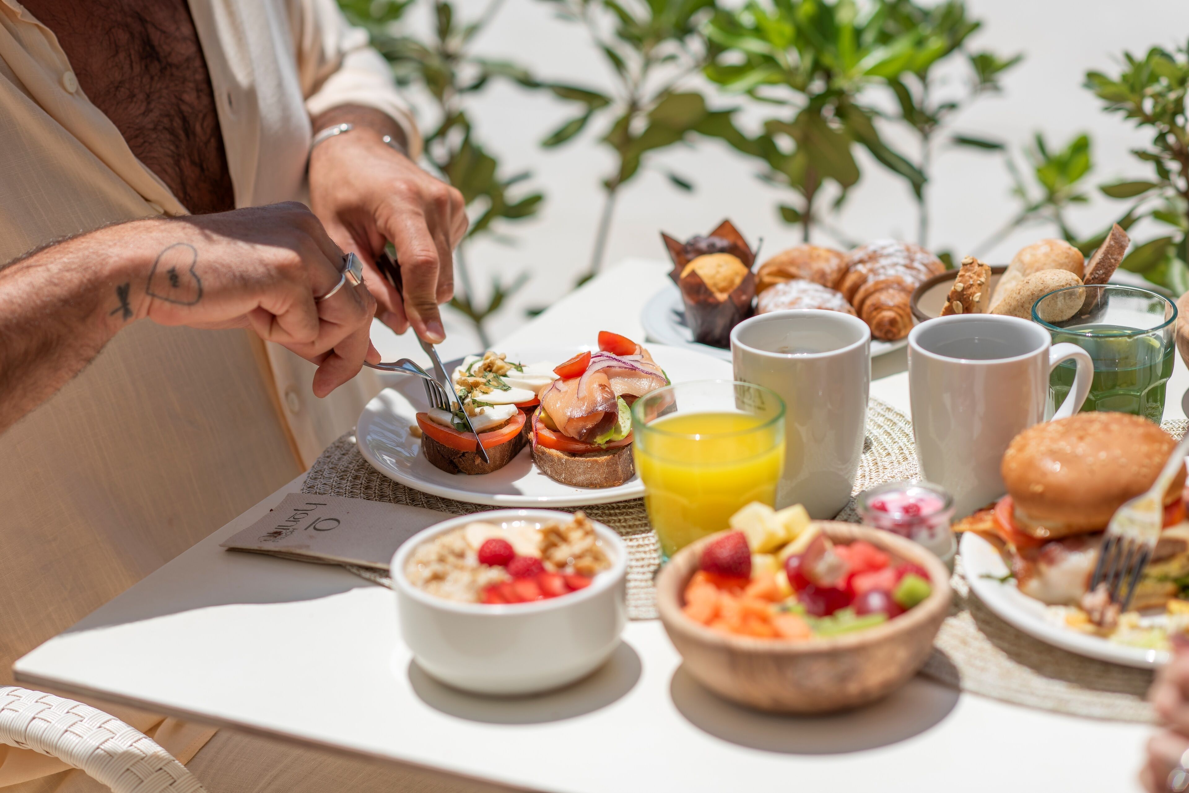 Een ontbijttafel met croissants, gebak, fruit en koffie.