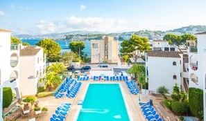 Una piscina al aire libre, sillones reclinables de piscina