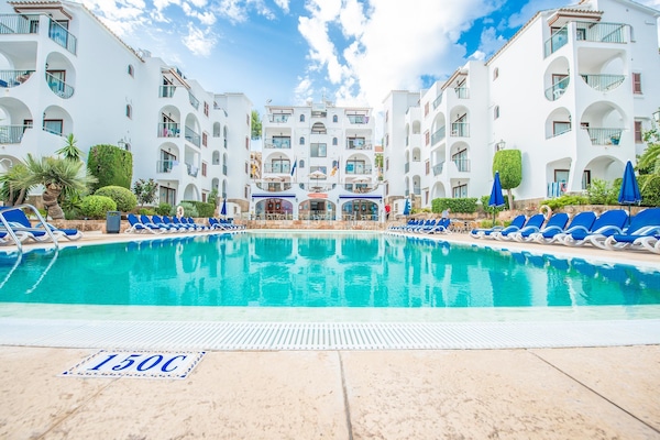 Una piscina al aire libre, tumbonas