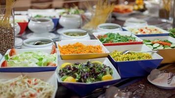 A buffet with various dishes including salads, pasta, and soups.