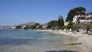 A beach with clear water, buildings, and trees. - Hoposa Bahía (Pollenca)