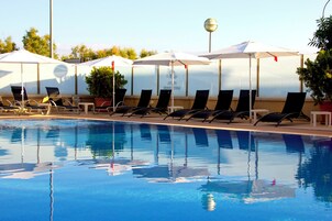 Una piscina al aire libre de temporada, sombrillas