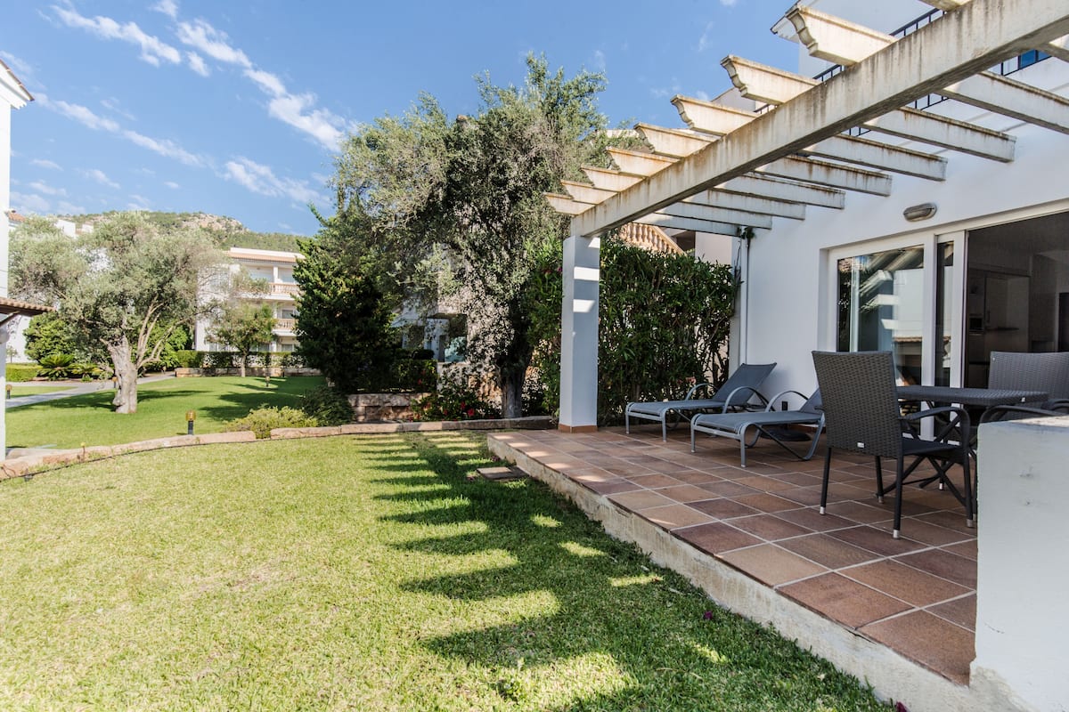 Un patio con mobiliario exterior y vistas del paisaje circundante.