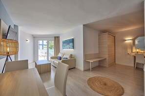 Una sala de estar moderna con un sofá, una mesa de centro, una mesa de comedor y una lámpara.