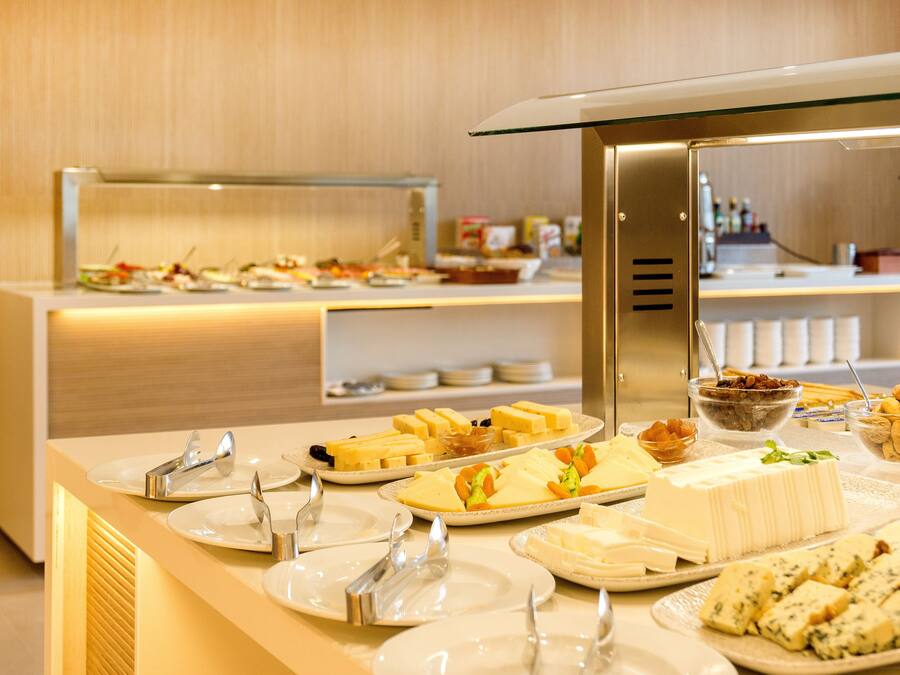Disposição de buffet com diversos alimentos e utensílios.