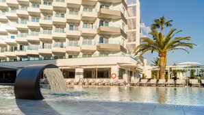 A modern hotel with a pool area, including a water feature and lounge chairs. - Tomir Portals Suites - Adults Only (+16) (Calvia)