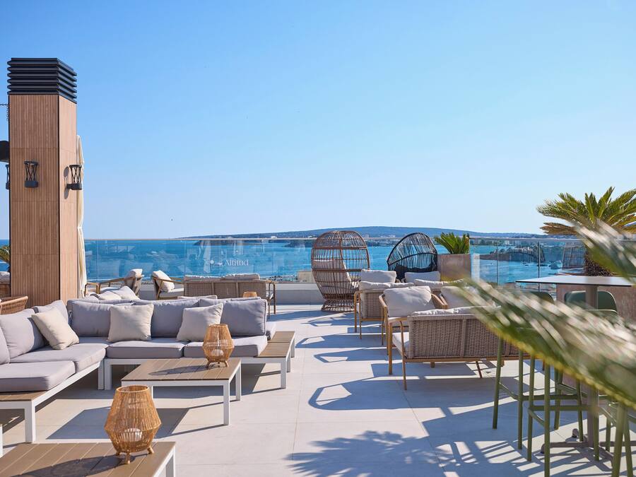 Une terrasse sur le toit avec des sièges, une haute tour et une vue sur la mer.