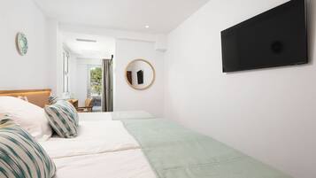 Habitación de hotel con cama, escritorio, silla, televisor y ventana.