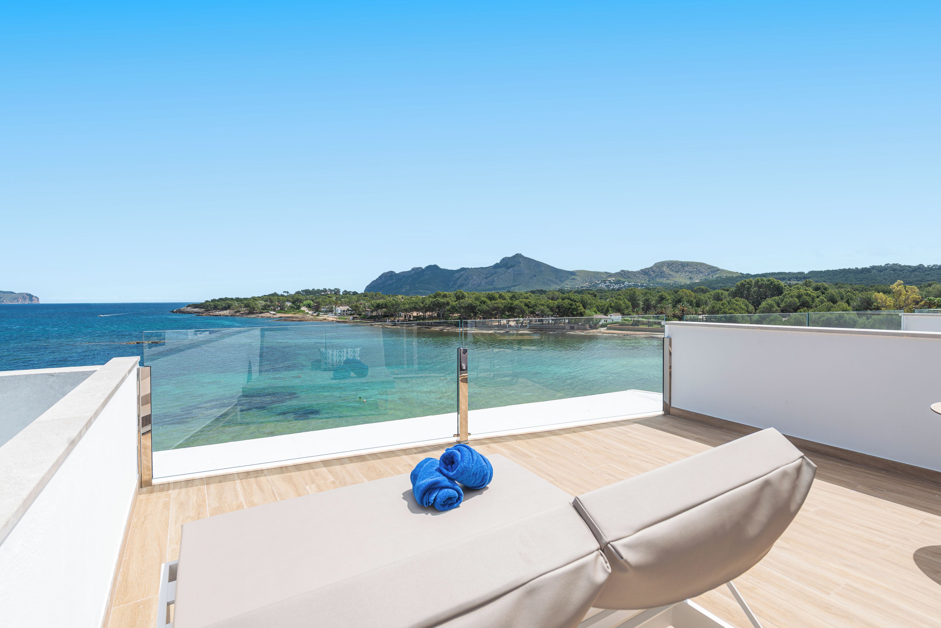 Un balcó amb una vista despejada del mar i una muntanya a la distància.