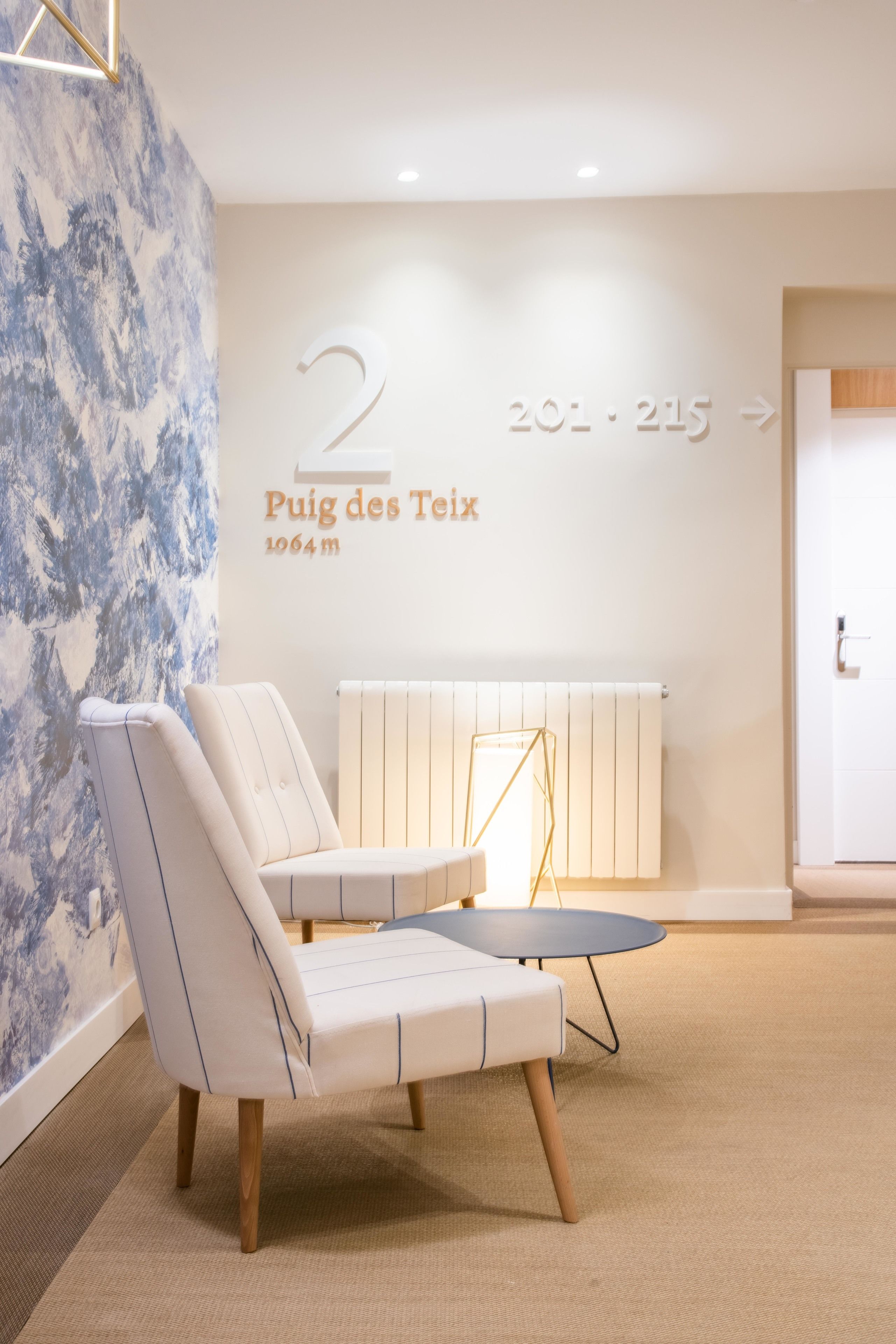 Een modern interieur met een zithoek, een wandbevestigd nummerbord en een radiator.
