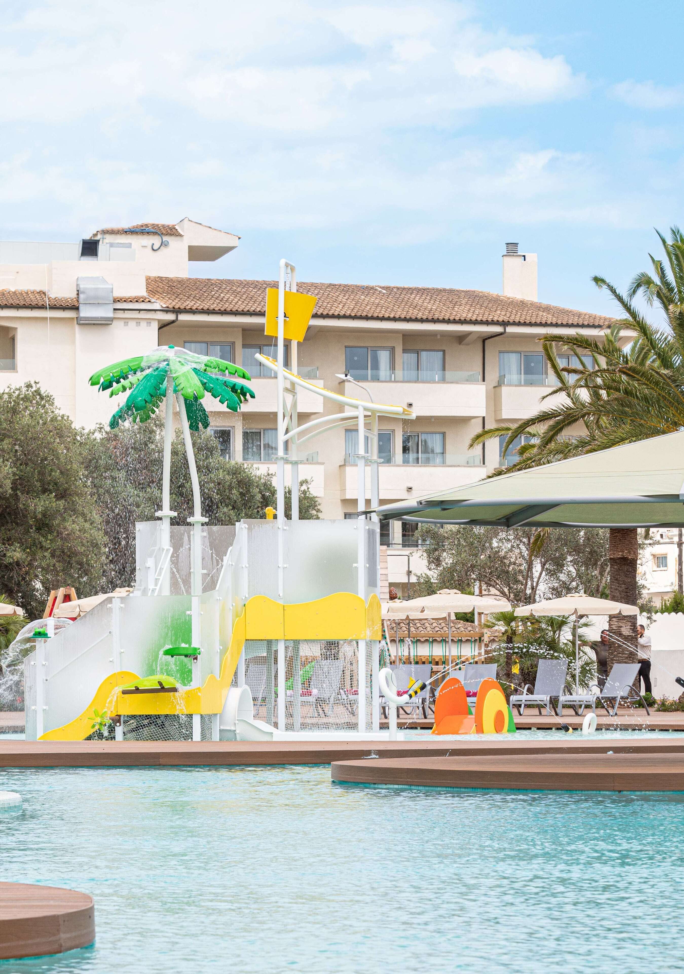 A swimming pool with a water slide and a palm tree decoration.