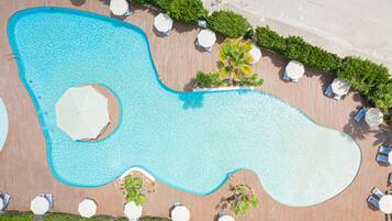 Een buitenzwembad, parasols bij het zwembad en ligstoelen