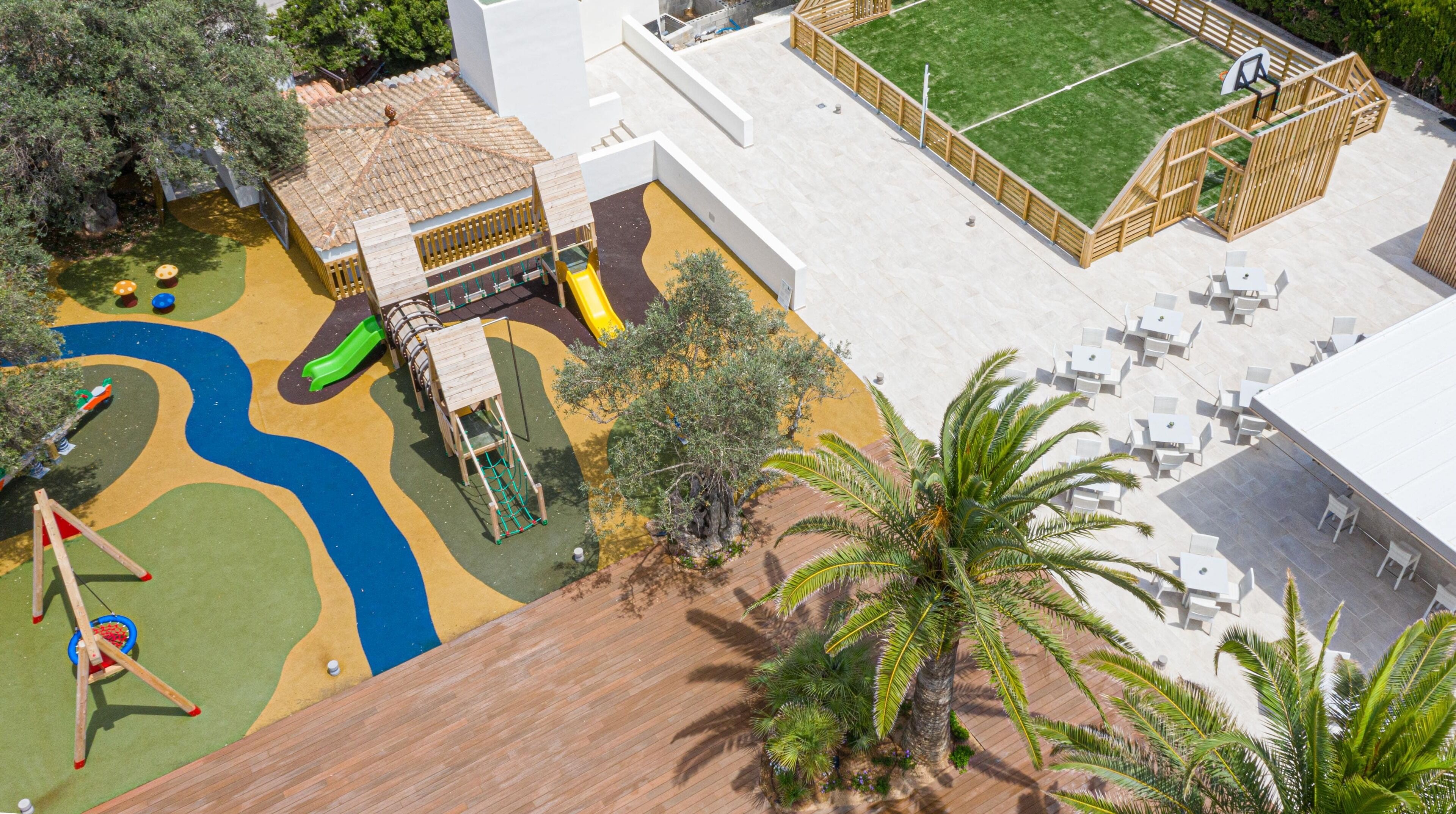A children's play area with a slide, climbing structures, and a small pool.