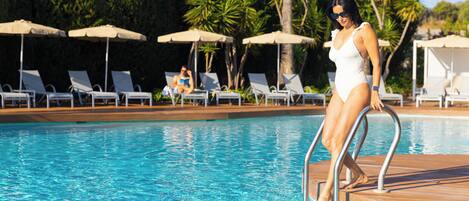 A poolside area with lounge chairs and umbrellas.
