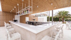 A modern outdoor bar area with a wooden ceiling, a long counter, and wicker chairs. - Hotel JS PortoColom Suites (Felanitx)