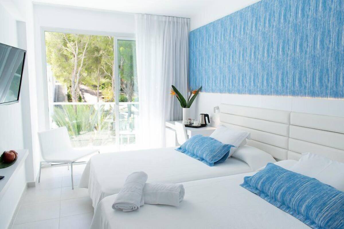 Habitación Confort, vista a la alberca | Ropa de cama de alta calidad y minibar