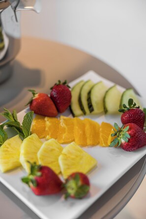 A white rectangular plate with sliced fruits including strawberries, kiwi, pineapple, and orange segments. - Hotel Cabot Playa Grande - Adults Only (Palma de Mallorca)