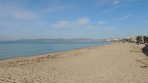A wide sandy beach with a clear blue sky and calm sea. - Hotel Cabot Playa Grande - Adults Only (Palma de Mallorca)