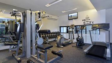 Ein Fitnessstudio mit unterschiedlichen Trainingsgeräten, Laufbändern und Kurzhanteln.