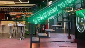 Een trap met een neonbord waarop staat 