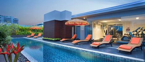 A swimming pool with lounge chairs and an exercise area.