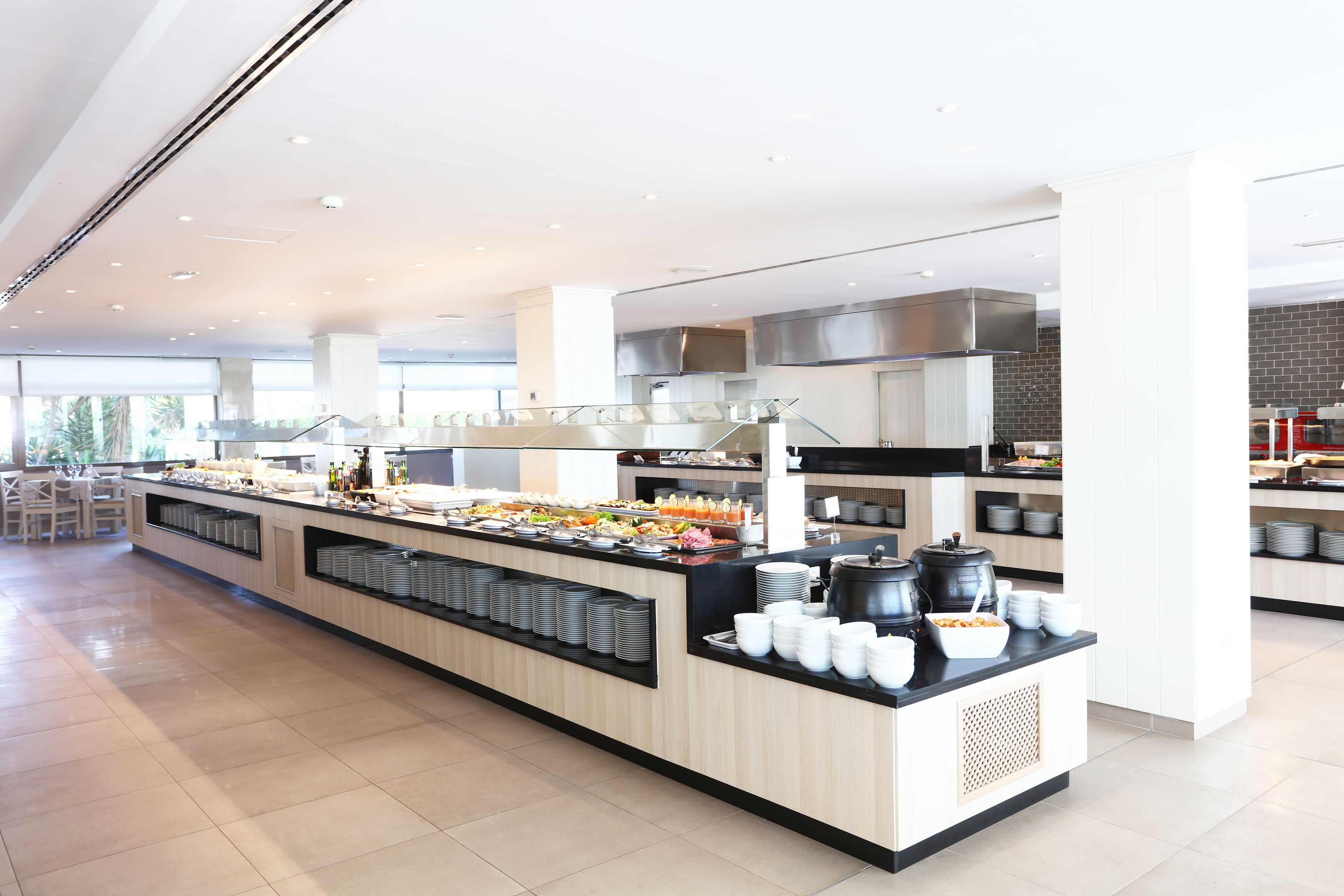 Una mesa de buffet moderna con una variedad de alimentos y una larga barra.