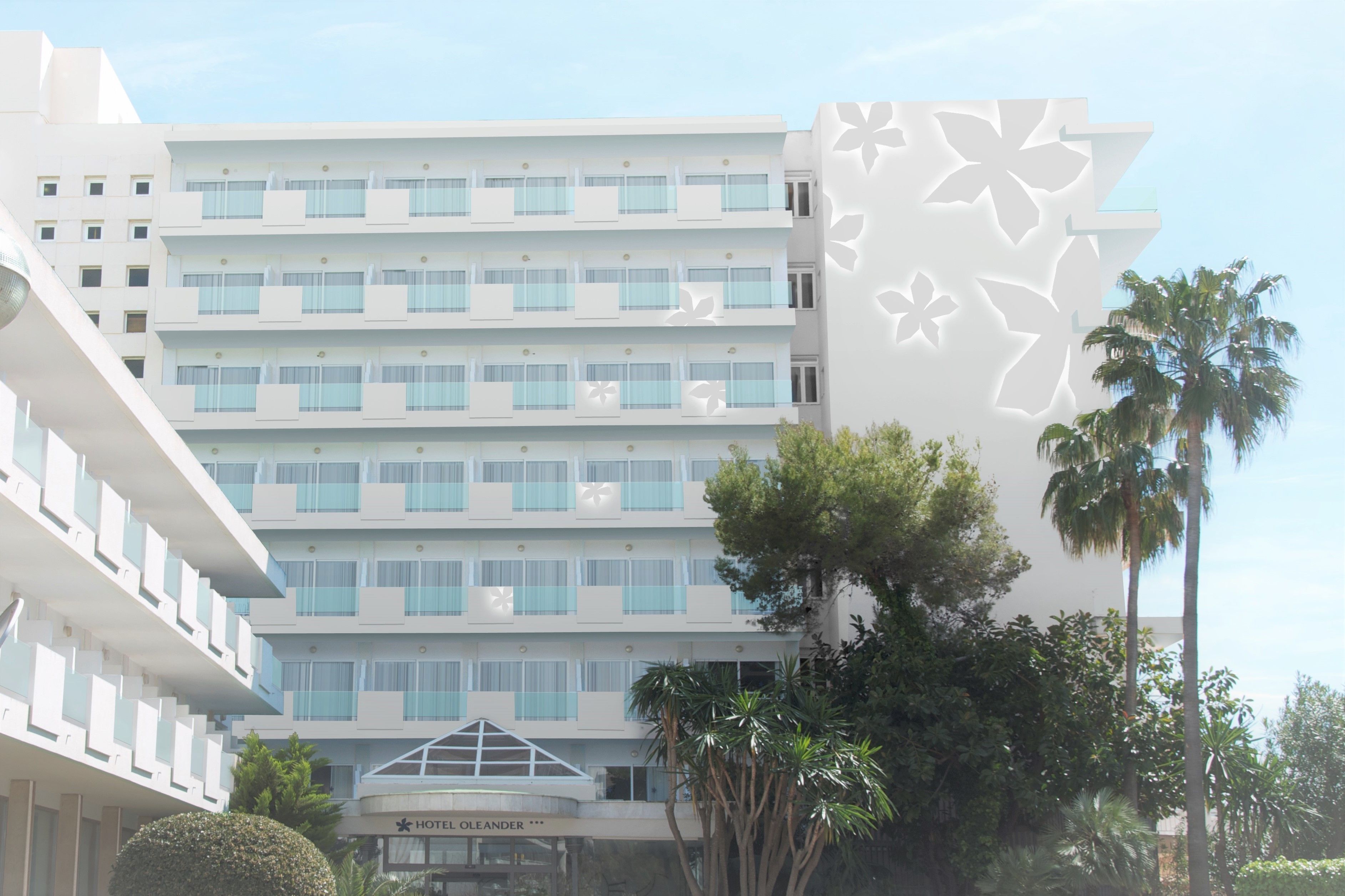 Un hotel a più piani con balconi, un ingresso centrale e palme.
