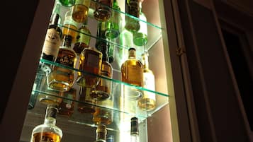 A display of various liquor bottles on a glass shelf.