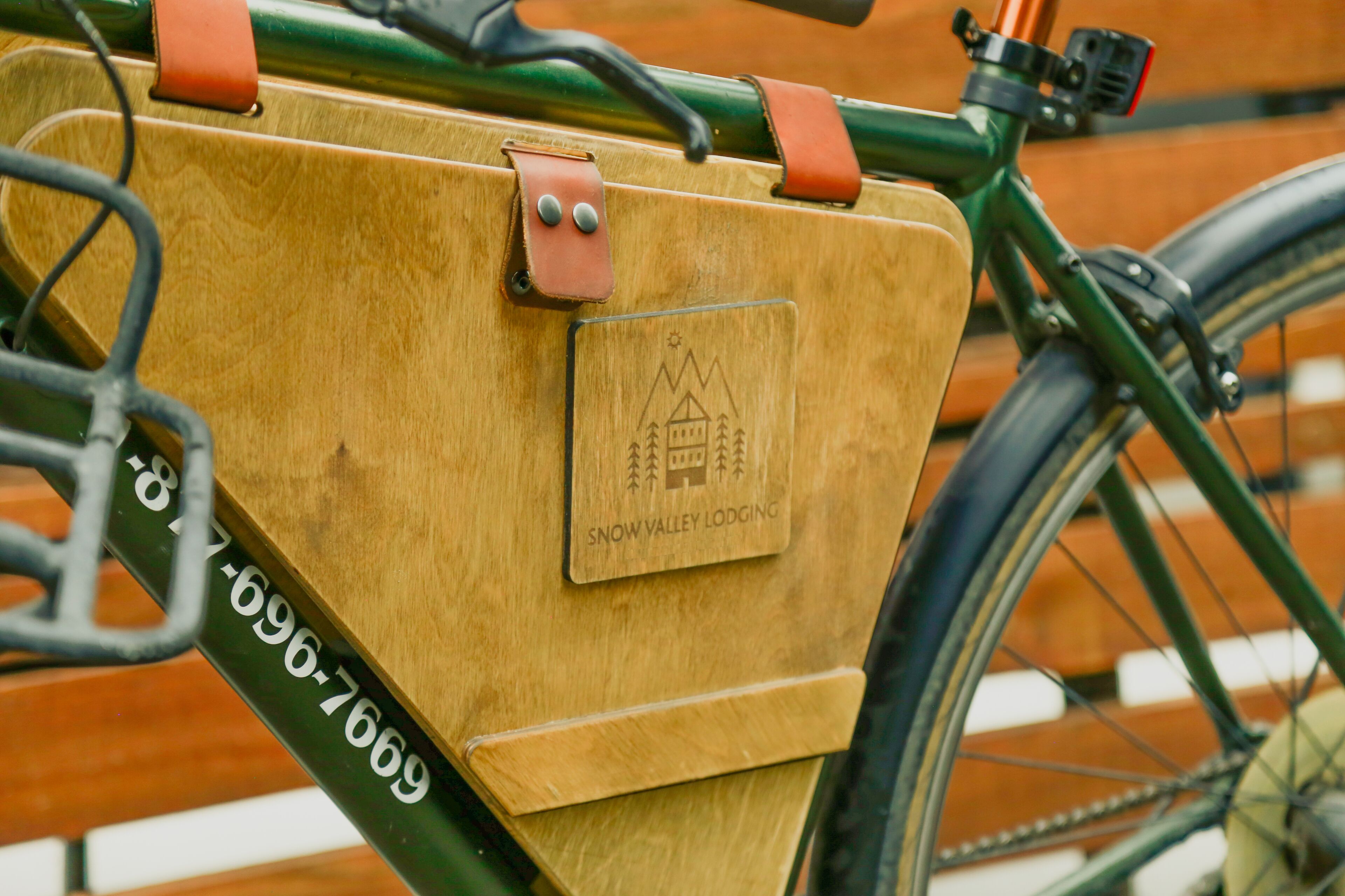 Uma cesta de bicicleta de madeira com uma etiqueta que diz "Snow Valley Lodging" e um número de telefone.