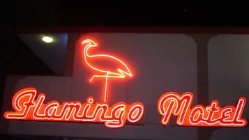 A neon sign for Flamingo Motel with a flamingo symbol.