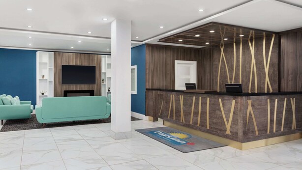 Ein moderner Empfangsbereich mit einem Holzbüro, einem Flachbildfernseher und einem blauen Sofa im Hintergrund.