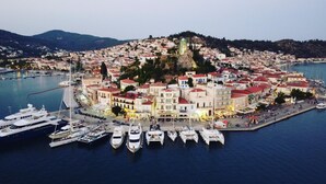 A coastal town with a marina filled with yachts and boats. - Manessi City Hotel (Poros)