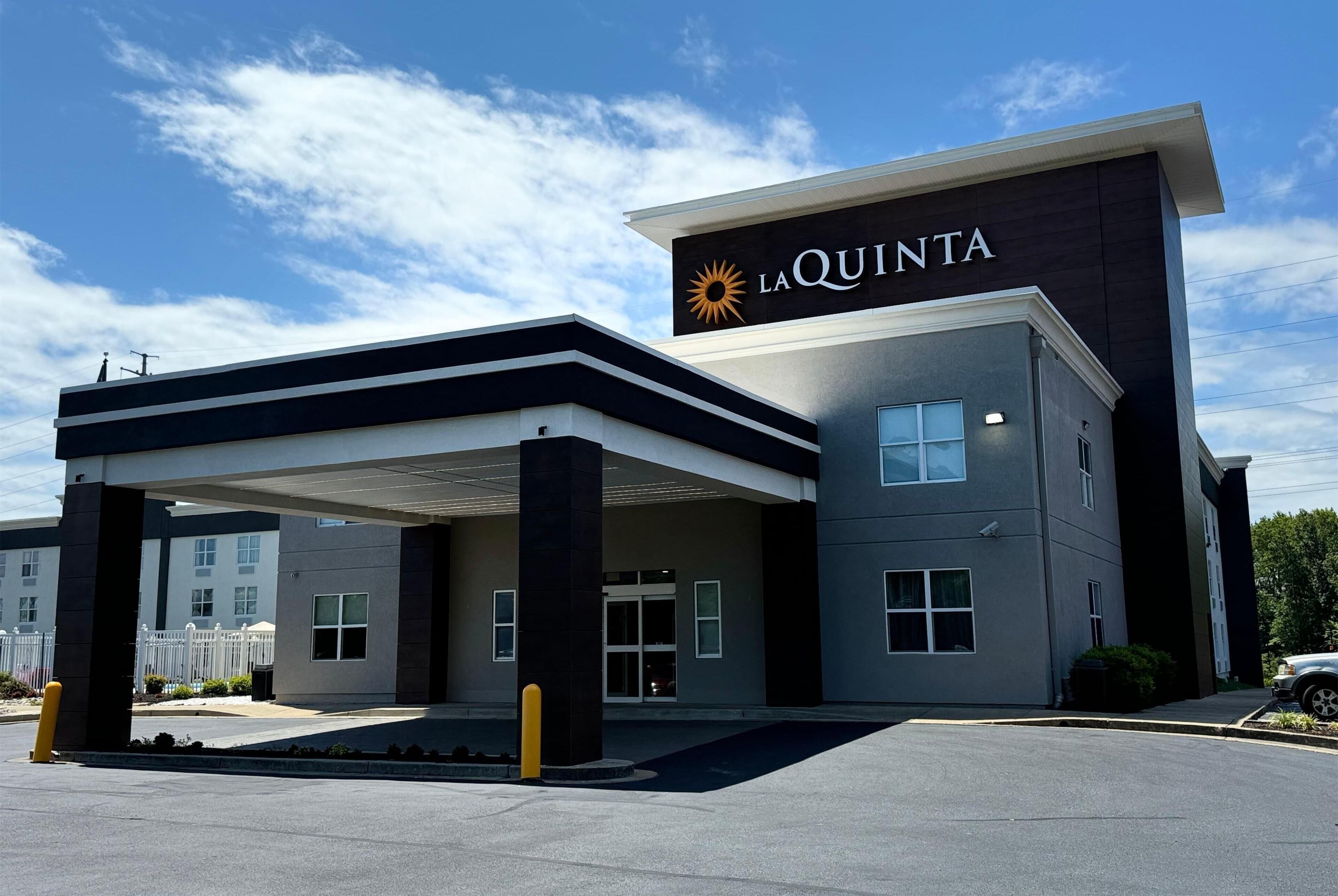 Un hôtel moderne, reconnaissable à son panneau « La Quinta » bien visible, doté d’une entrée abritée et d’un espace de stationnement.