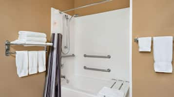 Une salle de bain équipée d’une baignoire, d’une douche et d’un porte-serviettes avec des serviettes pliées.