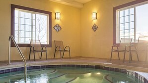 A pool area with chairs and a ladder, large windows, and wall-mounted lights. - La Quinta Inn & Suites by Wyndham Trinidad (Trinidad)