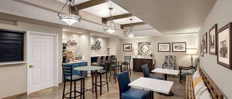 A spacious dining area with high ceilings, exposed beams, and pendant lighting.