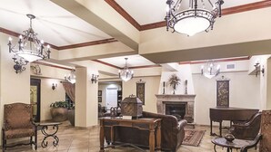 A spacious living room with a fireplace, elegant chandeliers, and classic furniture. - La Quinta Inn & Suites by Wyndham Trinidad (Trinidad)