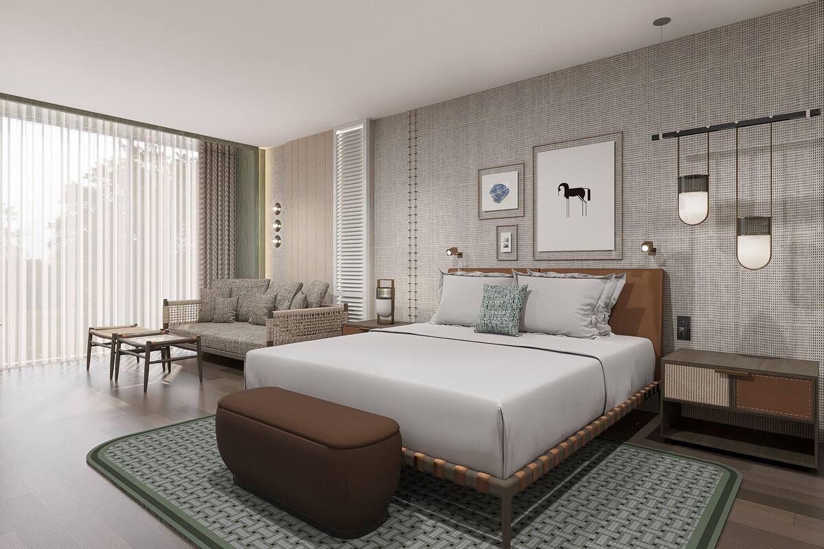 A modern bedroom with a large bed, a sofa, a coffee table, and a nightstand.