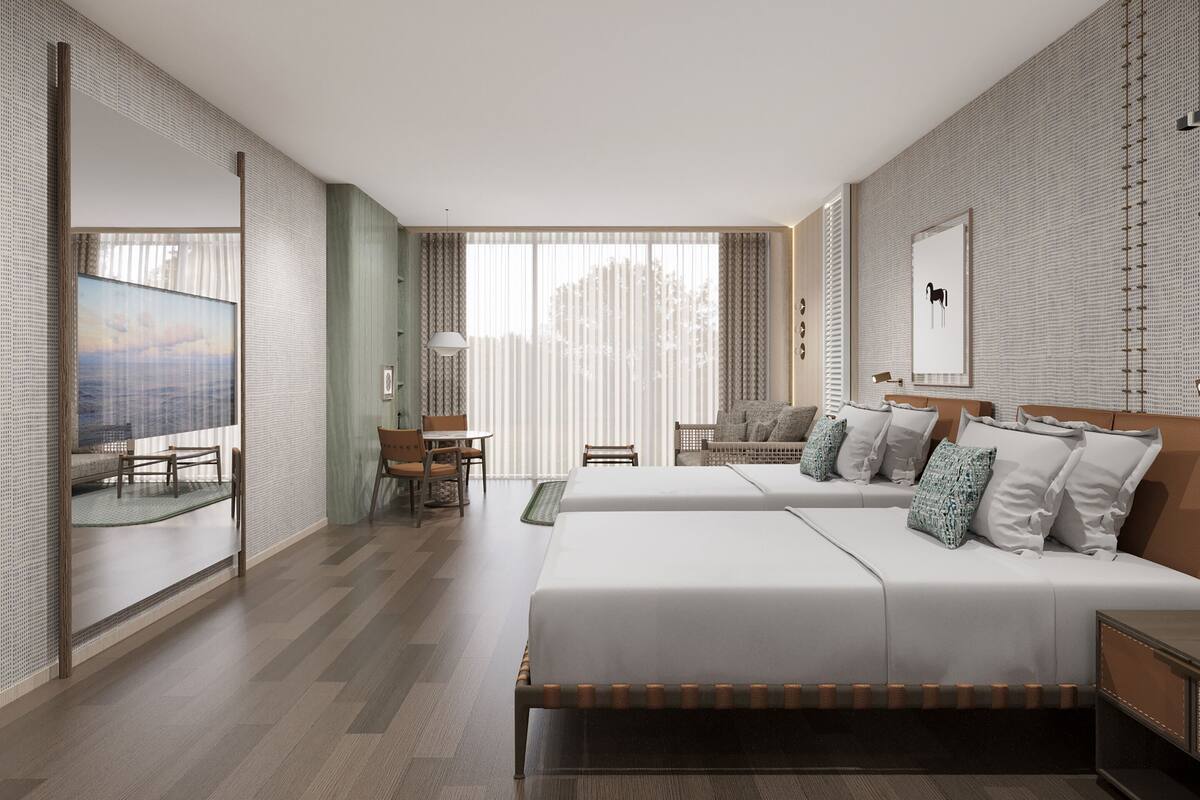 A modern hotel room with a large bed, a desk, and a seating area.