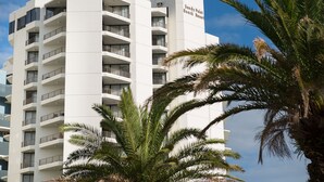 Un hôtel à plusieurs étages, doté de balcons et d’une enseigne indiquant : « Sandy Point Beach Resort ».