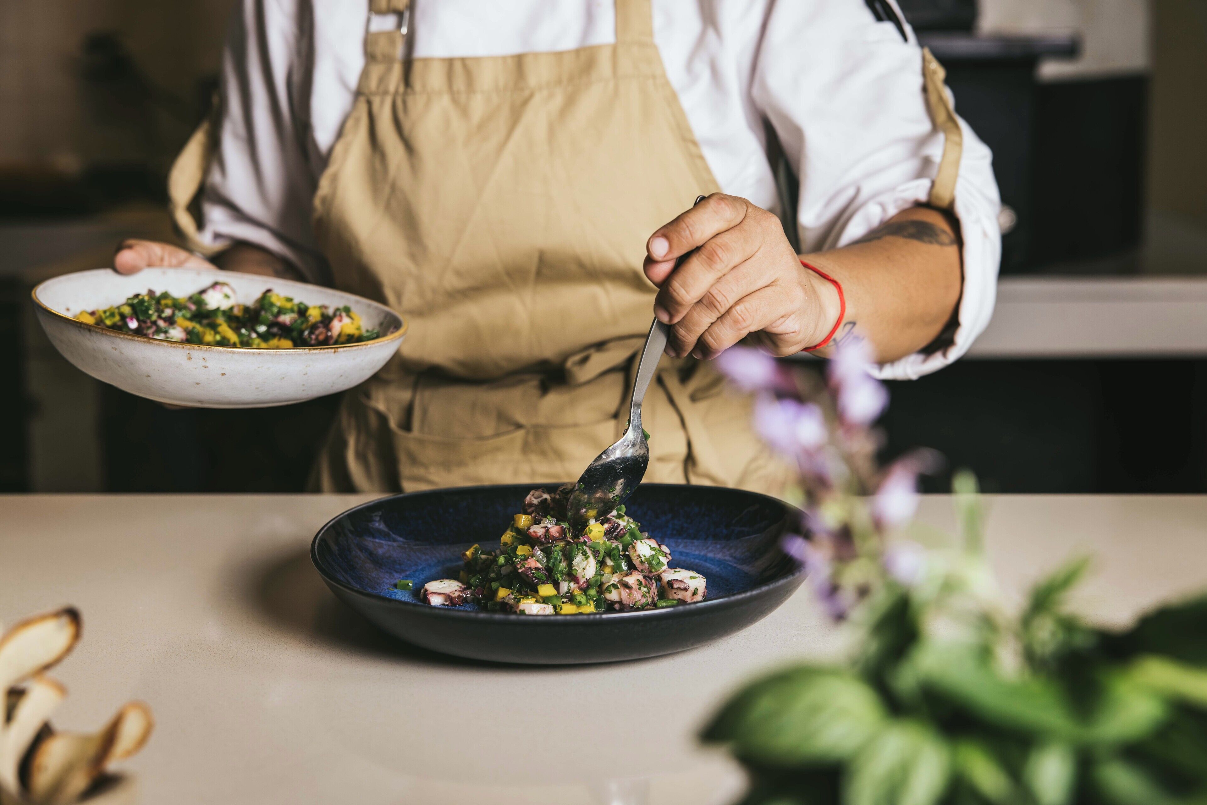 A person serving food from a bowl to a plate.