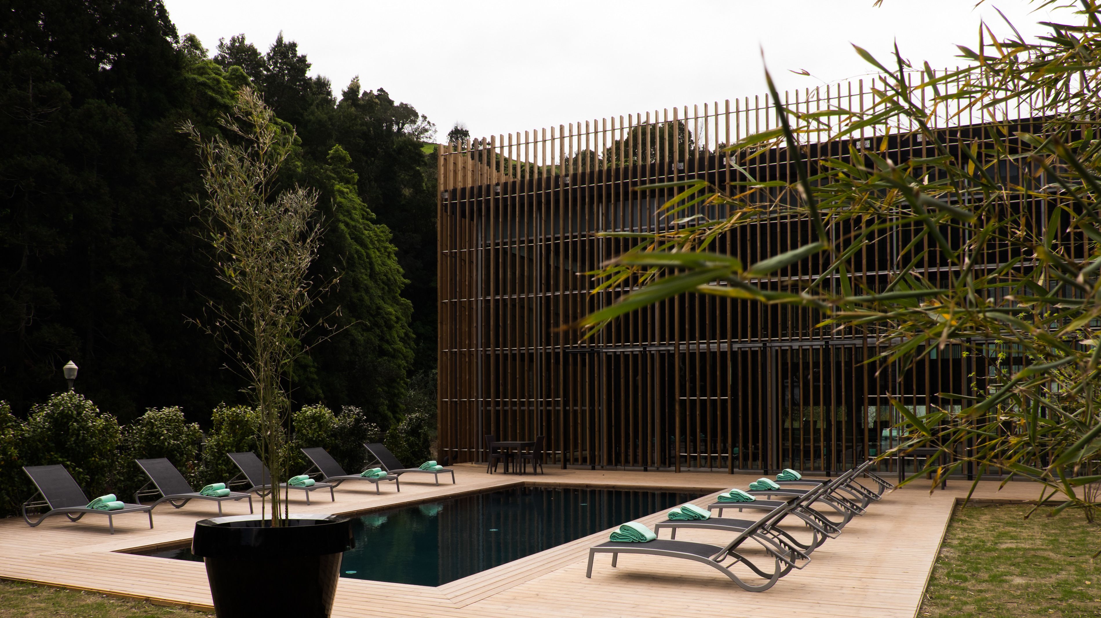 Uma área de piscina com espreguiçadeiras e um deck de madeira.